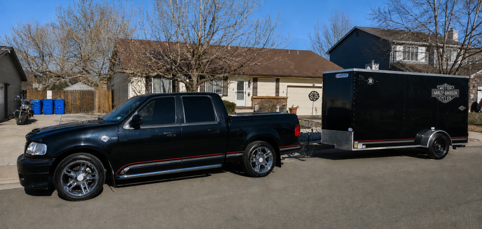 Black Harley-Davidson F-150 towing an enclosed motorcycle trailer